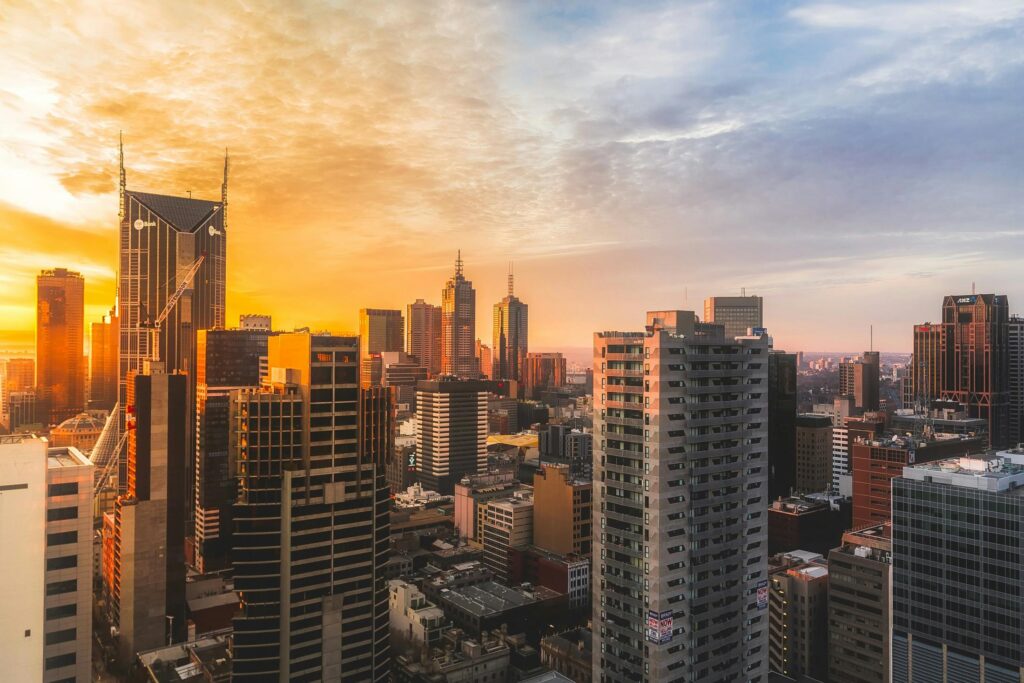 Stunning view of Melbourne's skyline at sunset, capturing modern skyscrapers and warm sky.