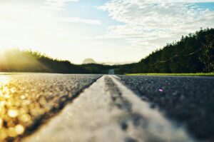 Serene road stretching through lush landscape during sunset in Kangar, Malaysia.